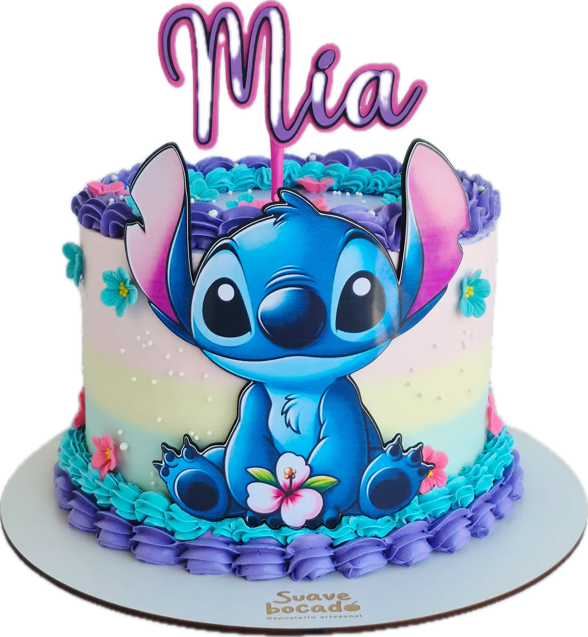 Torta personalizada de Stitch con cremas moradas y turquesa, flores tropicales y el nombre Mia